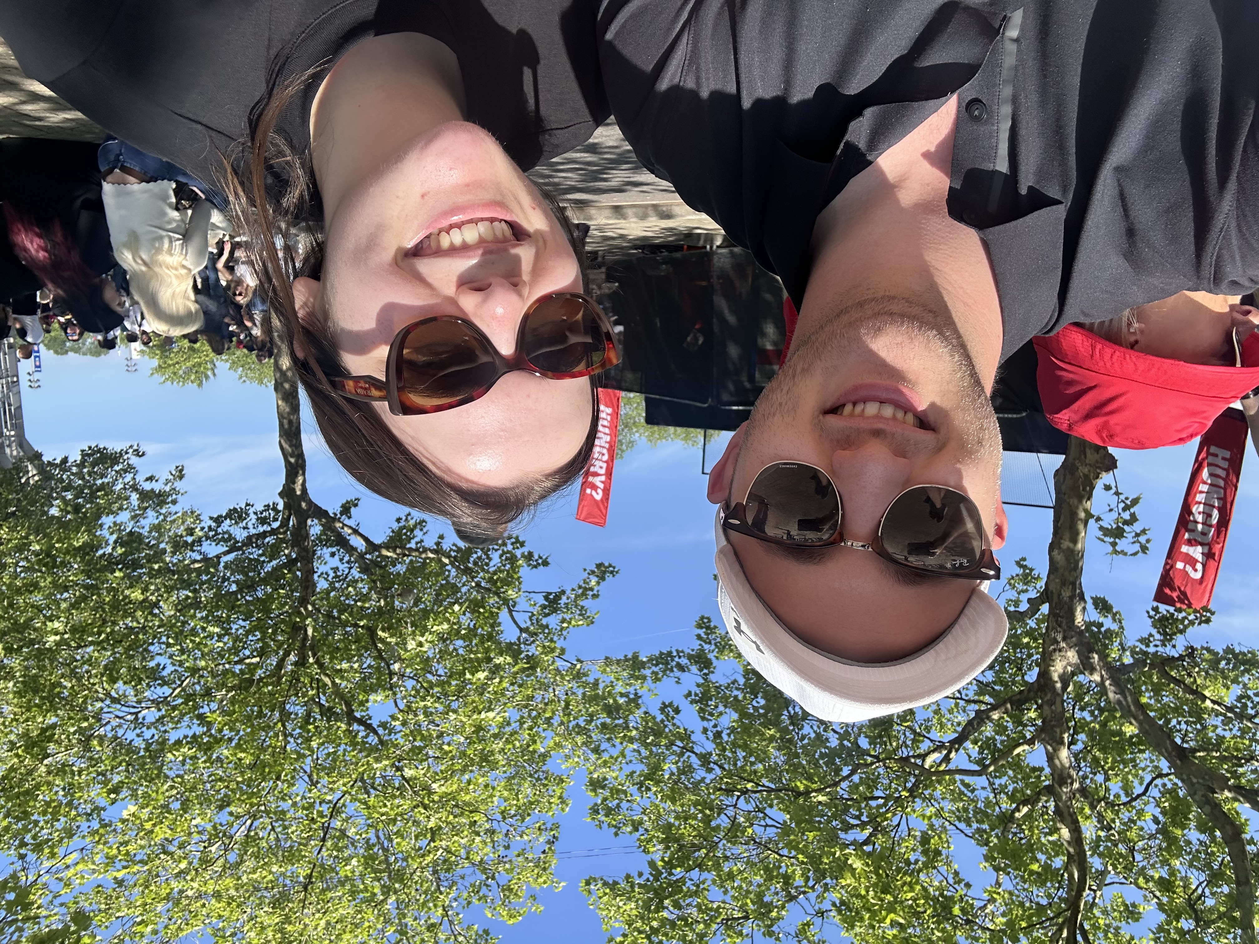 Claire and George smiling together at an outdoor event