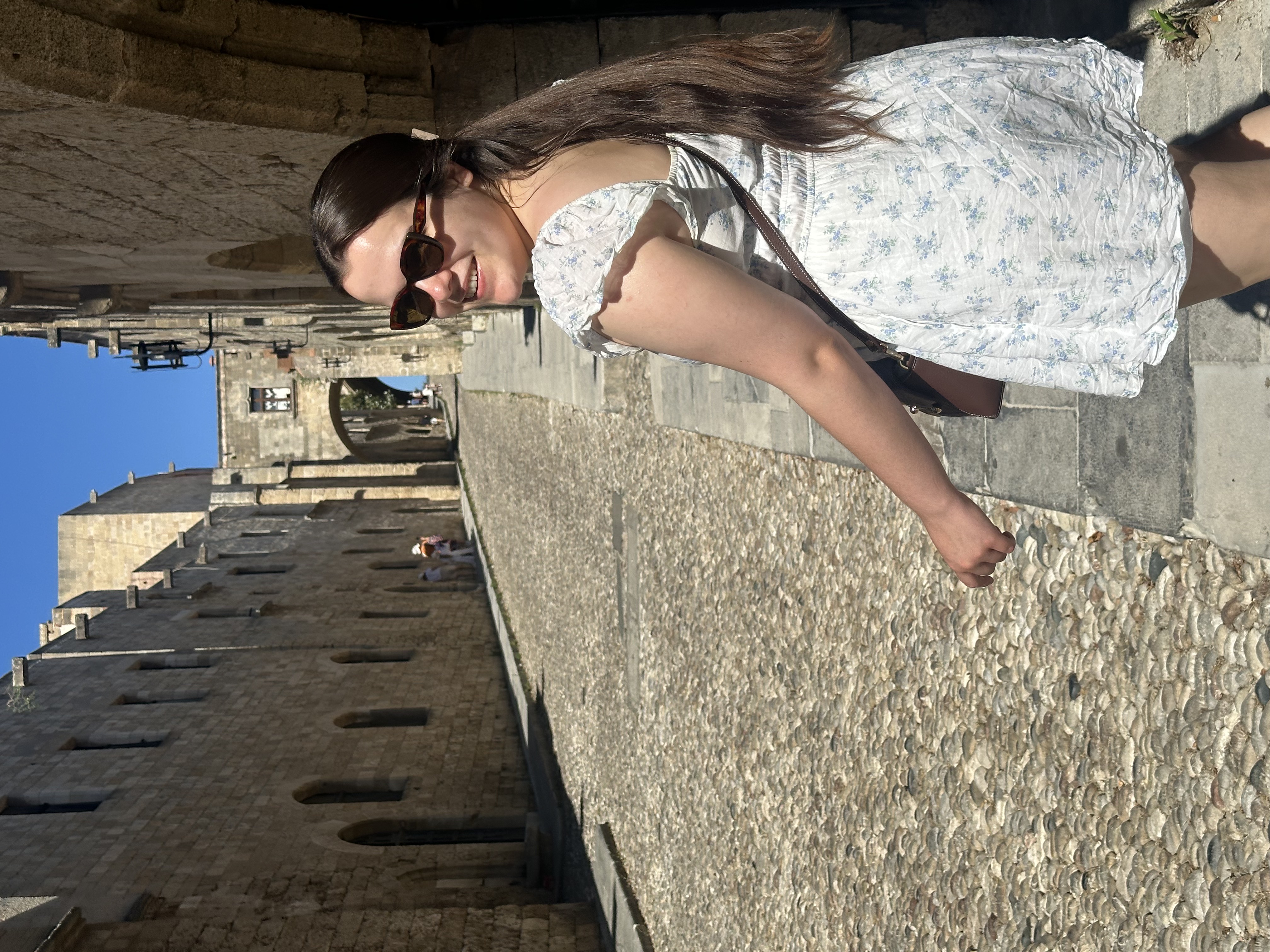 Claire exploring a sunlit street in Rhodes